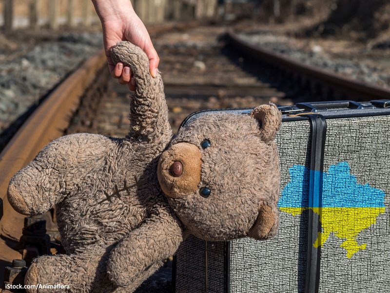 Ukraine Kind mit Koffer und Bär auf der Flucht 